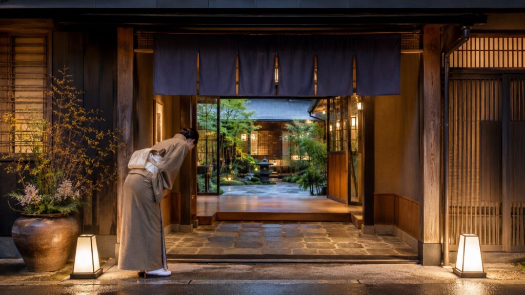 旅館の玄関でお客様をお辞儀で迎えるスタッフ(イメージ)